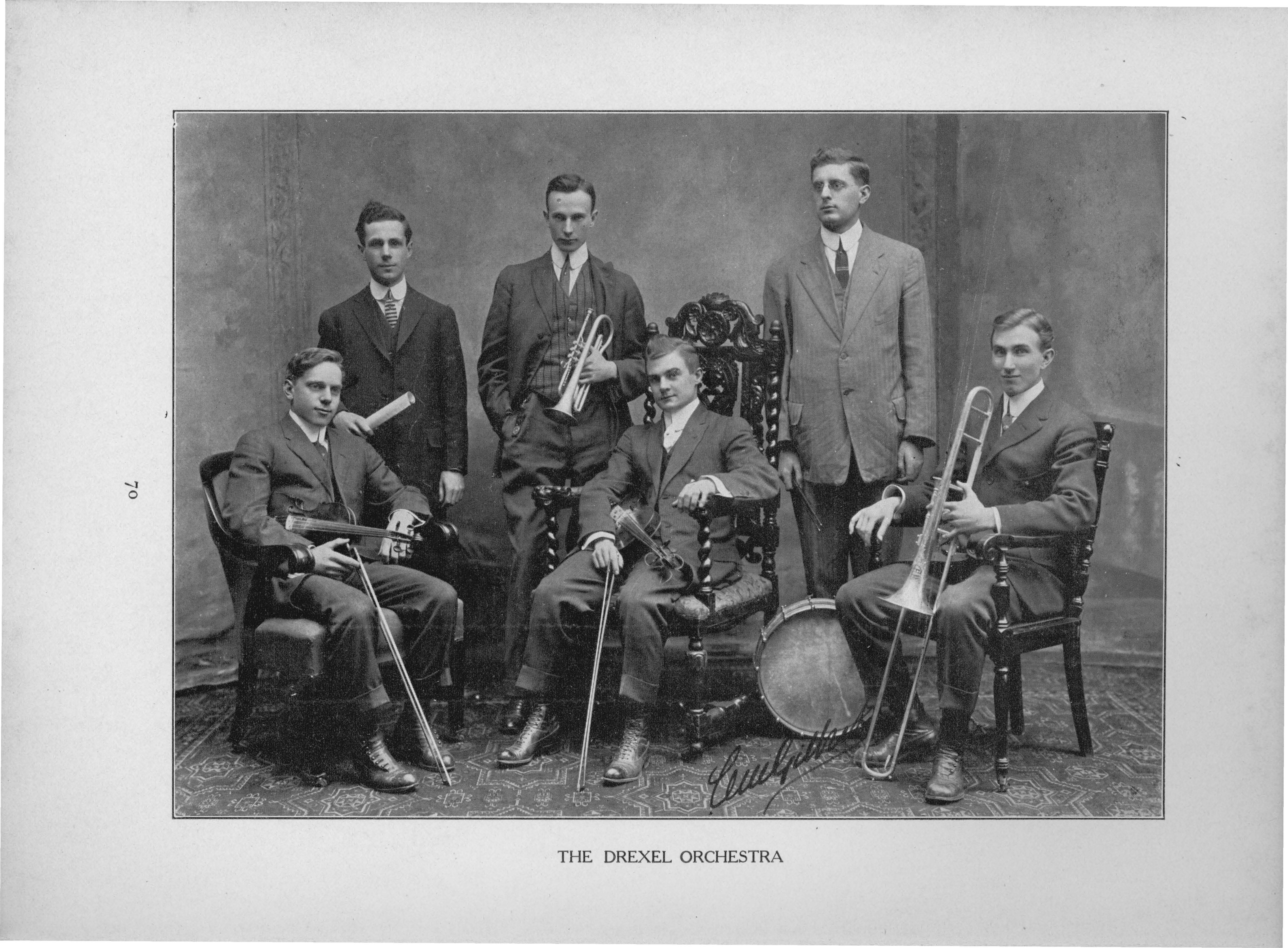 Six men stand in a semi-circle holding a variety of instruments